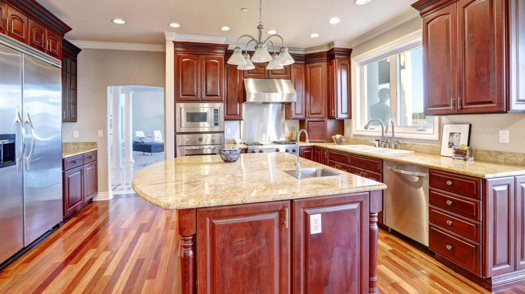 A kitchen with wood floors and granite counter tops.
